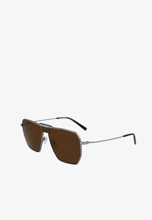 Brązowe okulary przeciwsłoneczne z geometrycznym metalowym ramieniem. Cechują się cienkimi srebrnymi zausznikami i kątowymi soczewkami, co tworzy odważny design.