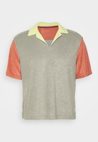 Polo paita lyhyillä hihoilla, jossa on vaaleanvihreä kaulus, harmaa vartalo ja oranssit hihat. Valmistettu pehmeästä, teksturoidusta kankaasta.