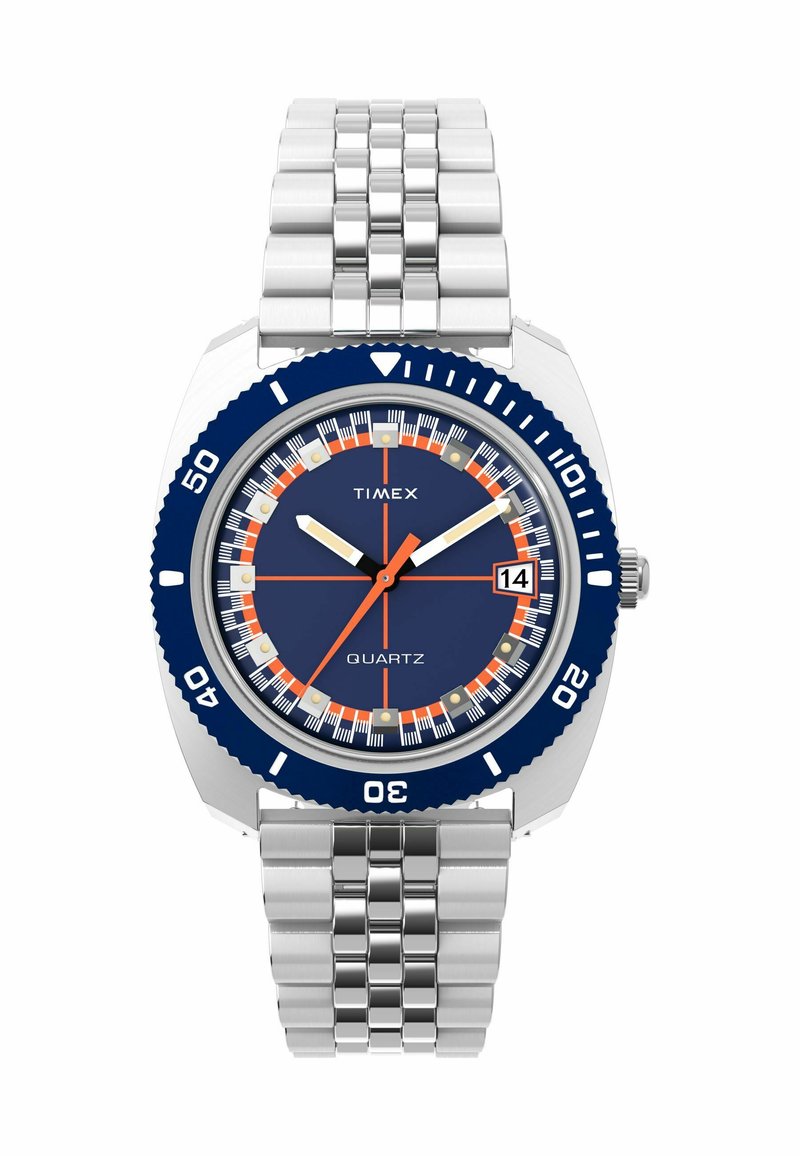 Montre quartz Timex avec un bracelet en acier inoxydable, un cadran bleu marine, des accents orange et une lunette tournante marquée par intervalles.