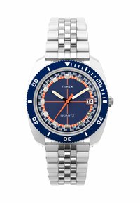 Montre quartz Timex avec un cadran bleu, des marquages orange et blancs, un affichage de la date à 3 heures, un bracelet en métal argenté et une lunette tournante bleue.