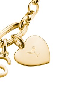 Bracciale in lega dorata con grandi anelli, dotato di un ciondolo a forma di cuore scolpito con un design geometrico e una superficie liscia.