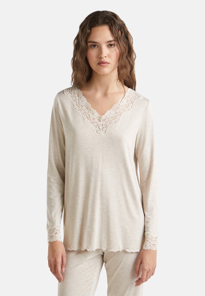 Beige dlouhý rukáv top vyrobený z měkké látky s okrajovým krajkovým výstřihem a krajkovým zdobením na manžetách. Má uvolněný střih a zakřivený spodní lem.