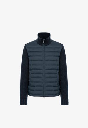 Veste hybride marine avec un devant matelassé et des manches en tricot texturé. Col montant et fermeture éclair à l'avant. Poignets côtelés.