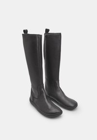 Mustad musta nahast põlvini ulatuvad saapad, millel on sile tekstuur, ümar varvas ja külgmine tõmblukk. Tugev tald ja minimaalne õmblusdetail.