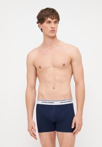 Tamnoplave bokserice s bijelim pojasom s natpisom "JACK & JONES", izrađene od mekog i rastezljivog materijala.