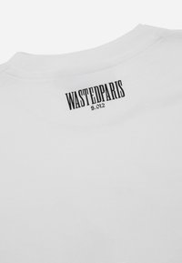 White cotton t-shirt featuring a crew neck and black text "WASTEDPARIS 5.012" printed near the back neck area. Smooth texture.