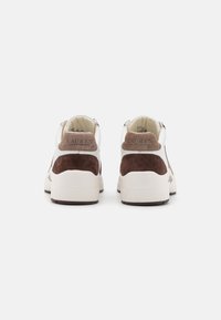 Brązowe zamszowe i białe skórzane sneakersy z wyściełanym kołnierzem, z logo na pięcie i grubą, białą gumową podeszwą.