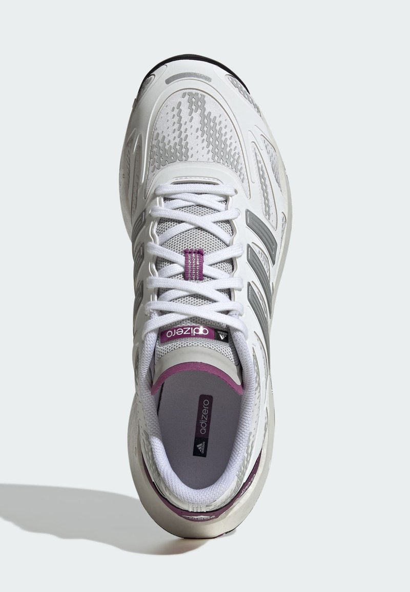 Baskets de sport blanches avec une tige en mesh, accents violets et rayures grises. Présentent un bout arrondi, une semelle rembourrée et des lacets plats.