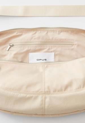 Beige schoudertas gemaakt van een gladde nylon stof, met een rits hoofdcompartiment, een binnenzak en een merklabel. Voorzien van een brede, geweven schouderband.