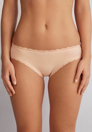 Perzikkleurige onderbroek met kant en een gladde, rekbare stof. Heeft delicate golvende randen aan de tailleband.
