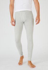 Leggings de color gris claro fabricados con una tela suave, que presentan un diseño ajustado con un bolsillo frontal. La tela tiene una textura suave y un ligero estiramiento.