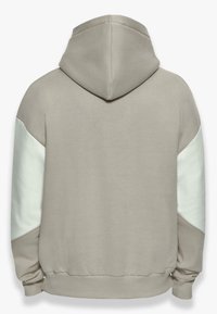 Kapuutsiga sverk softbeige kangast, millel on valged aktsendid varrukatel. Given relaxed fit ja soonikkäärised all.