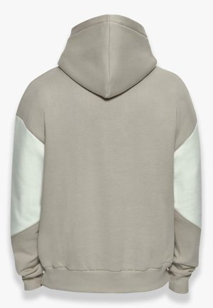 Sudadera con capucha de tejido beige suave con paneles de acento blancos en las mangas, que presenta un corte relajado y puños de canalé en el dobladillo.