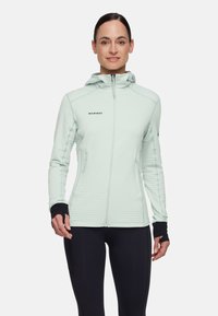 Giacca con cappuccio verde menta chiaro con zip frontale, trama a coste, dettagli neri sui polsini e tasche laterali. Adatta per attività all'aperto.