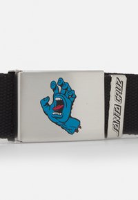 Zwarte geweven riem met een zilveren metalen gesp. De gesp heeft een blauw cartoonhandontwerp met een rode tong en een expressieve mond.