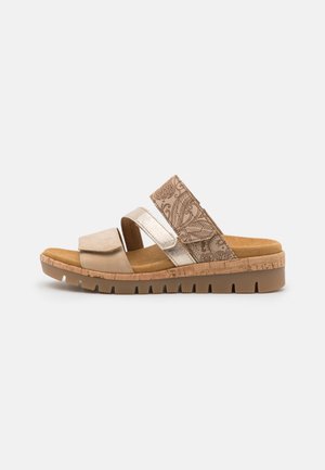 Klapki na płaskiej podeszwie z dwoma szerokimi paskami, jednym metalicznym złotym i drugim w wzór paisley. Podeszwa przypominająca korek w jasnobrązowym kolorze z teksturowanym bieżnikiem.