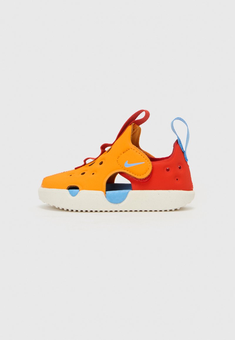 Nike sko med en blanding av oransje og rød overdel, blå detaljer, perforert design, elastiske lisser og en hvit såle, med utsparinger på sidene.