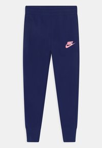 Námořnické modré Nike tepláky s růžov�ým logem na levém stehně, elastickým pasem, zúženými nohavicemi a bočními kapsami. Vyrobené z měkké, elastické látky.