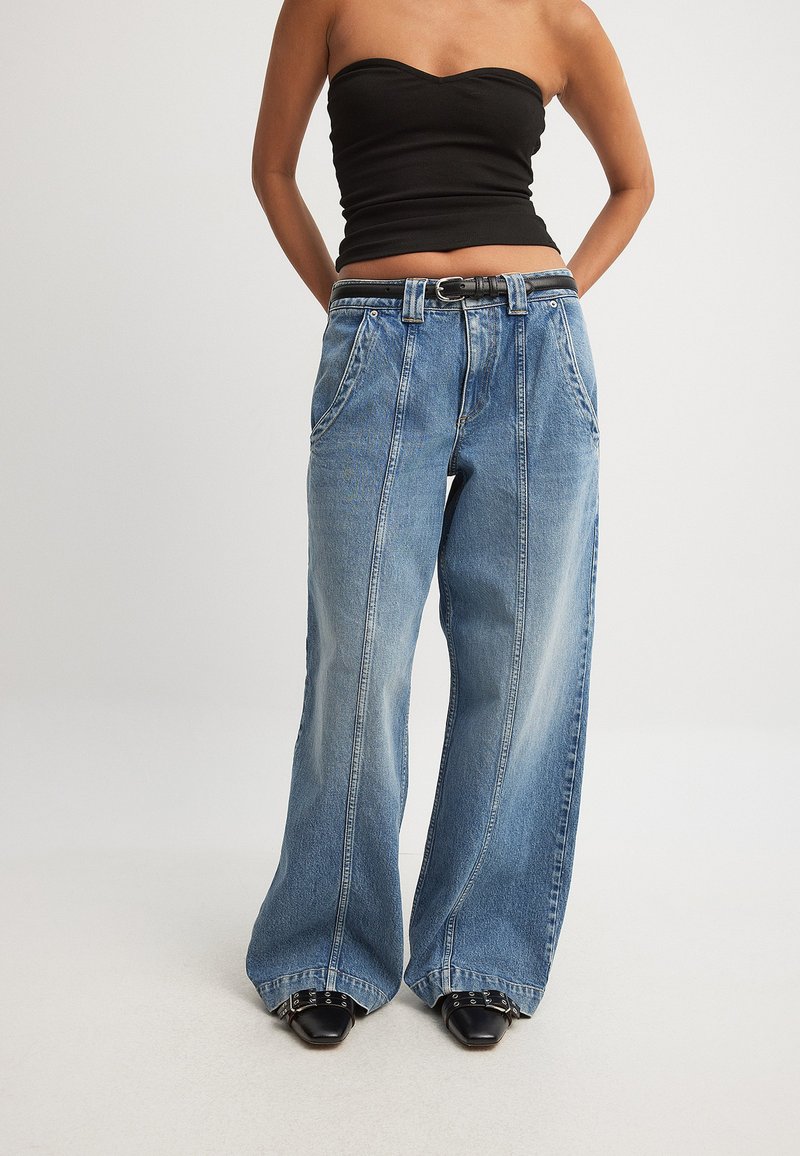 Širši traper hlače v svetlo modri barvi z izbledelim izgledom, z visokim pasom, zankami za pas in dvema sprednjima žepoma.