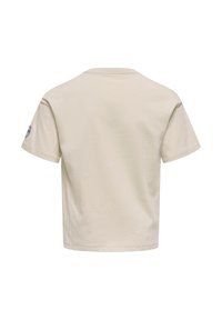 Lys beige kortærmet T-shirt med rund halsudskæring. Har et rundt logopatch på venstre ærme. Glat bomuldsstof.
