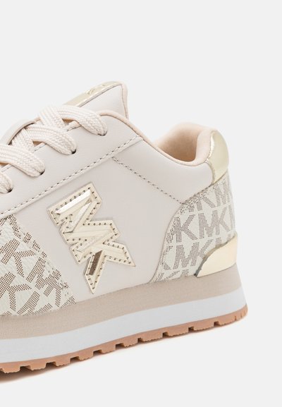 Μπεζ αθλητικά παπούτσια με λείο δερμάτινο επάνω μέρος και δίχτυ με σχέδιο. Διαθέτει μεταλλική λεπτομέρεια, υφασμάτινη σόλα και επίπεδα κορδόνια.