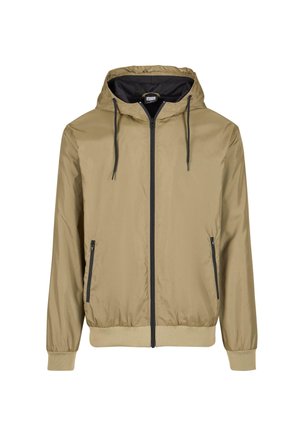 Giacca a zip con cappuccio color tan e interno nero. Caratterizzata da lacci regolabili, due tasche frontali e polsini e orlo a coste. Leggera, con una texture liscia.