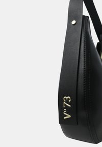 Zwarte leren handtas met een gebogen vorm, gouden hardware, zijlogo "V°73" en een gestructureerde afwerking. Inclusief verstelbare schouderriem.