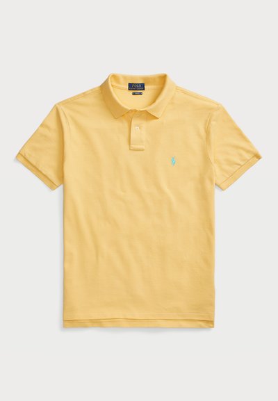 Kollane polo särk, mis on valmistatud sileda kangaga, klassikalise kraega, kolme nupuga kinnitusega ja väikese sinise brodeeritud logoga rinnal.