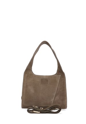Kleine braune Lederhandtasche mit kurzem Griff und abnehmbarem Schulterriemen, am Boden aufgerollt vor weißem Hintergrund.
