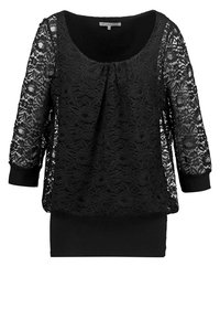 Blouse noire à manches longues avec superposition en dentelle florale, encolure arrondie, devant plissé et ourlet et poignets ajustés unis.