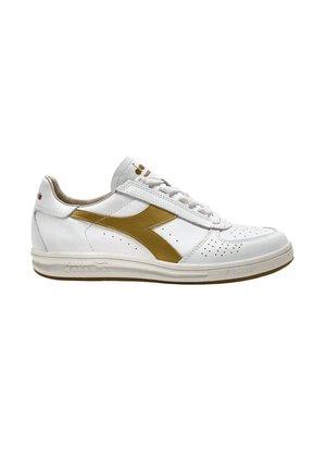 Sneaker in pelle bianca con dettagli dorati e perforazioni. Presenta lacci bianchi piatti e una suola in gomma, progettato per un uso casual.