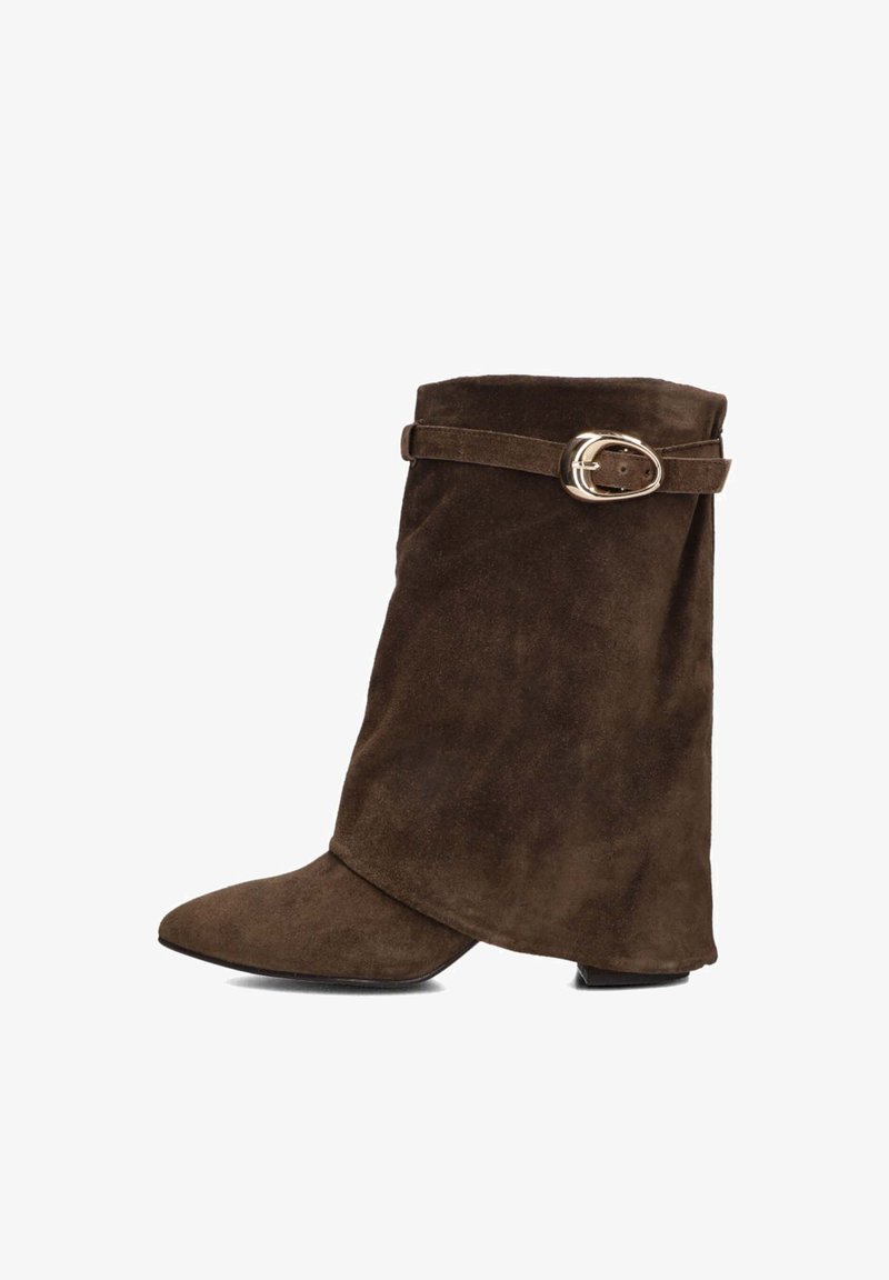 Bruine suède enkellaars met een spitse neus, gevouwen design en een zijband met een gouden gespaccent. Platte hak.