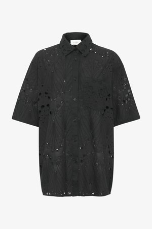 Fekete, laza szabású ing, hímezett kivágott mintákkal, hegyes gallérral, rövid ujjal és egyetlen zsebével a mellrészen.