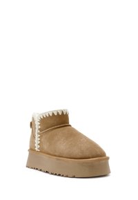 Bruine suède enkelboot met witte grove rand, featuring een dikke beige platformzool en een ronde neus.