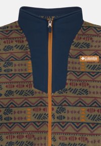 Giacca in pile con un vivace motivo geometrico in tonalità terrose, parte superiore blu navy, zip arancione e logo Columbia sul petto.