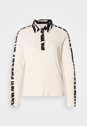 Μπλούζα πόλο με μακριά μανίκια, εκρού σώμα, γιακά και μανίκια με μαύρο σχέδιο ζέβρας, με κουμπωτό πάτιλο και ριμπ υφή.