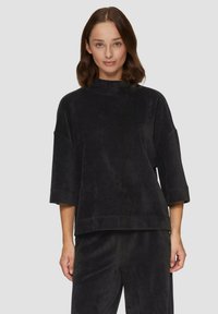 Mustmustest mustriga kõrge kaelusega, lahtise lõike ja lühikeste varrukatega. Materjalil on pehme tekstuur ja ribidega muster. Sobib vastavate tõmblustega.