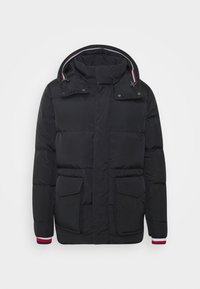 Giacca nera imbottita con cappuccio, dotata di due tasche frontali, polsini a coste con accenti rossi e bianchi, e una texture liscia e lucida.