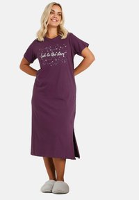 Lila bomullsnattlinne med korta ärmar, med texten "titta mot stjärnorna" och en grafisk konstellation, sidov slit, och avslappnad passform.