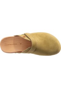 Mockasiner i dämpad gul färg med en träsol. Har en rund tå och ett korsrem-design över vristen. Storlek 37.