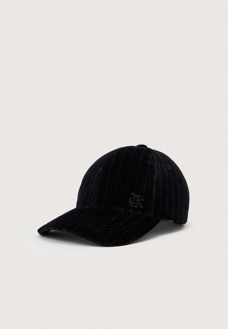 Fekete bársonyos baseball sapka finom csíkokkal és hímzett logóval az elülső bal panelen, világos, egyszerű háttérrel bemutatva.