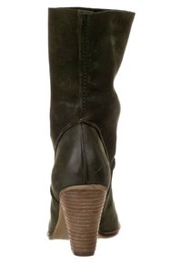 Bota de tobillo de cuero verde con acabado texturizado, tacón afilado y detalles de costuras cosidas a lo largo de la parte trasera para mayor estructura y estilo.