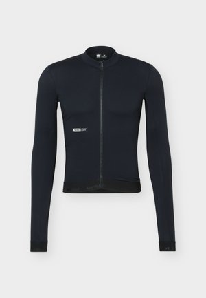 Melnā velosipēda jaciņa ar garām piedurknēm un priekšējo rāvējslēdzēju, neliels balts "SRX" logotips kreisajā krūšu daļā un pieguļošs siluets uz vienkārša fona.