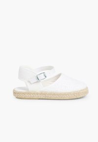 Zapato de lona blanco tipo slingback con un patrón floral decorativo, tira elástica, suela de yute, punta redondeada y diseño plano.