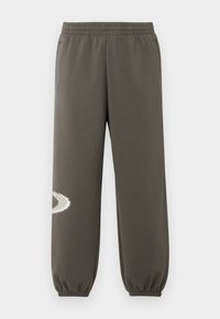 Mørke olivengrønne sweatpants med elastisk talje, sidelommer, en tætsiddende pasform og et hvidt takket logo på venstre ben.