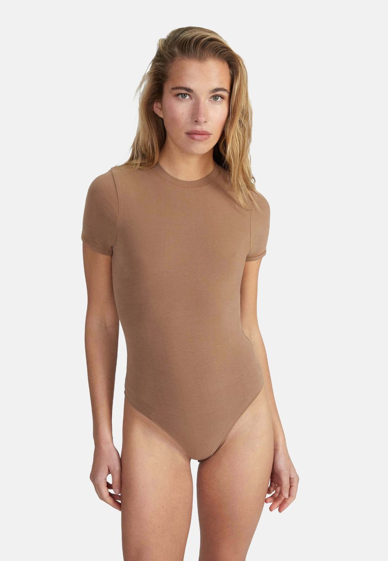 Body brun ajusté avec des manches courtes et un col rond. Fabriqué en tissu lisse avec un design sans couture et un minimum de détails.