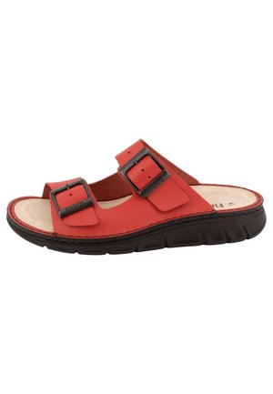 Red open-toe sandal with two adjustable black metal buckles and a thick black sole, featuring a beige cushioned footbed.