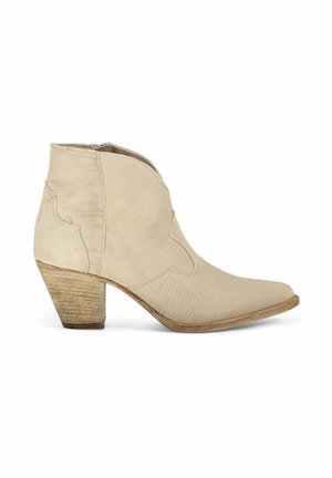 Bottes beiges à la cheville avec un bout pointu, en tissu texturé, avec des coutures décoratives et un talon en bois empilé. Fermeture éclair sur le côté pour un enfilage facile.
