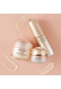 Shiseido Benefiance hudvårdset som innehåller två krämburkar och ett serum, alla med släta, glansiga ytor i mjuka rosa och guldtoner.