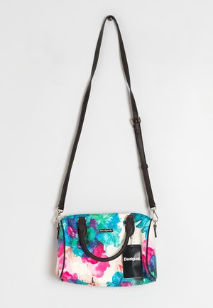 Bolso con estampado floral con flores en tonos turquesa, rosa y púrpura, asas negras y correa larga ajustable para el hombro en negro colgado sobre fondo blanco.